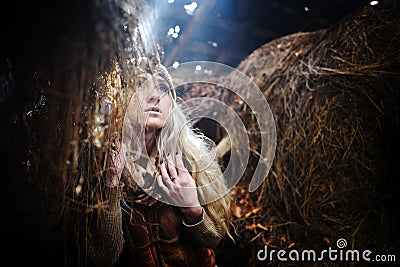 Beautiful woman relaxing in straw in autumn in smoky room Stock Photo