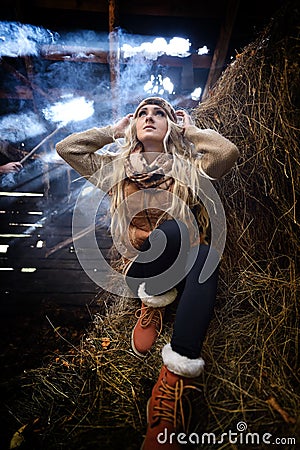 Beautiful woman relaxing in straw in autumn in smoky room Stock Photo