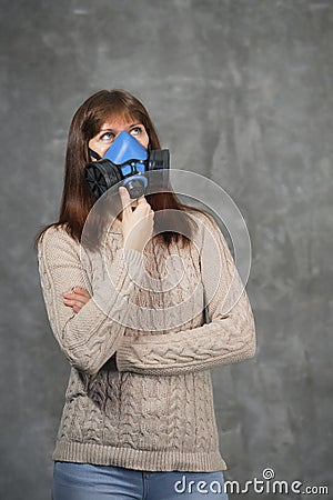 Beautiful woman in respirator stand on dark background Stock Photo