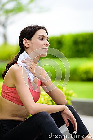 Beautiful woman runner has used a white towel wipe her face after running in the garden Stock Photo