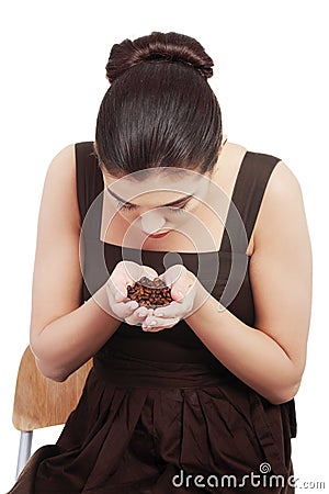Beautiful woman sitting and holding coffee beans in hands. Stock Photo