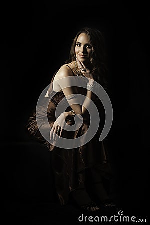 https://thumbs.dreamstime.com/x/beautiful-woman-sitting-portrait-wearing-jewelry-bronze-satin-evening-dress-down-her-hand-resting-her-leg-33882893.jpg