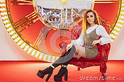 Beautiful woman smiling Christmas mood sitting on a red chair Stock Photo