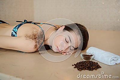 a beautiful woman in spa salon having spa therapy with coffee done by a masseur Stock Photo