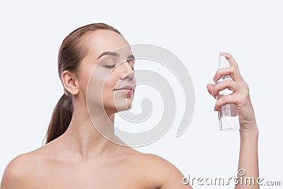 Beautiful woman spraying on face isolated on white Stock Photo