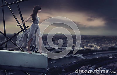 Beautiful woman standing on a cornice Stock Photo