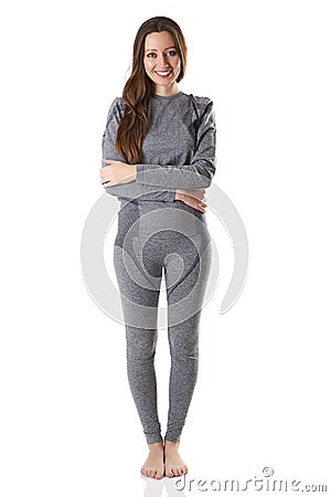 Beautiful woman staying hugging herself with her arms in gray sports thermal underwear. Stock Photo