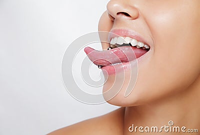 Beautiful woman sticking out her tongue and showing young piercing Stock Photo