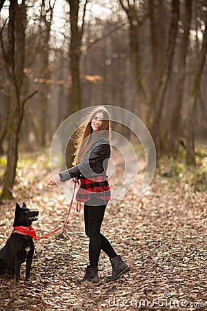 Beautiful woman stroking her dog outdoors. Pretty girl playing and having fun with her pet by name Brovko Vivchar Stock Photo