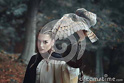 Beautiful woman in surreal forest with an owl Stock Photo