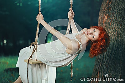 Beautiful woman on a swing in the forest Stock Photo