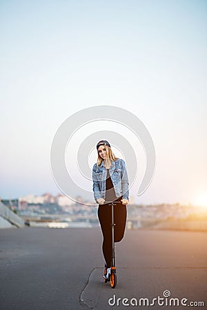 Beautiful woman travelling by scooter. Happy woman into the park Stock Photo