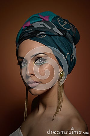 Beautiful woman with turban. Young attractive female with turban and golden accessories. Beauty fashionable woman Stock Photo