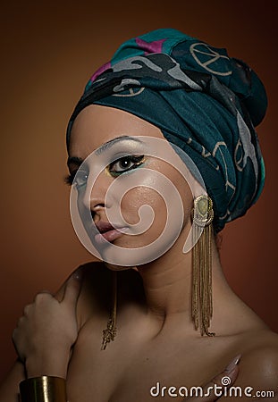 Beautiful woman with turban. Young attractive female with turban and golden accessories. Beauty fashionable woman Stock Photo