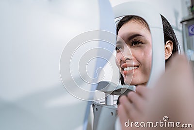 A beautiful woman is undergoing an examination using an eye examiner Stock Photo