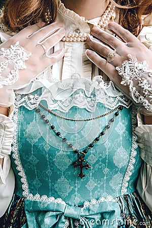 Beautiful rich woman in vintage blue dress. Cross. Victorian lady. Elegant Stock Photo
