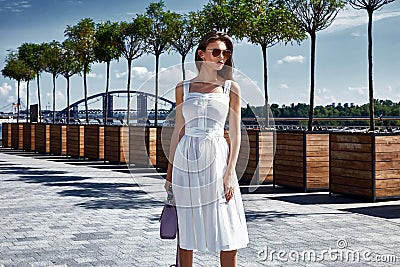 Beautiful woman walk on the street square wear fashion style clothes white cotton dress accessory bag jewelry sunglasses alley av Stock Photo