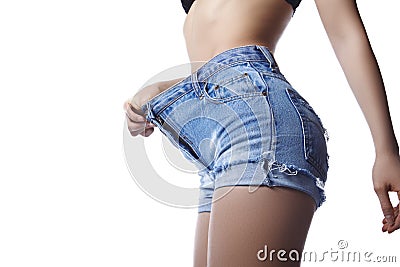 Beautiful woman is wearing big blue jeans shorts and showing her weight loss. Perfect body shapes, sports hips Stock Photo