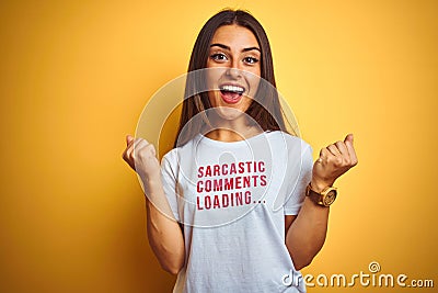 Beautiful woman wearing fanny t-shirt with irony comments over isolated yellow background celebrating surprised and amazed for Stock Photo