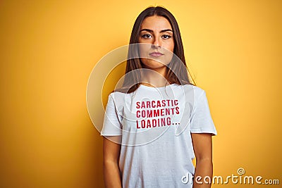 Beautiful woman wearing fanny t-shirt with irony comments over isolated yellow background with serious expression on face Stock Photo