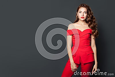 Beautiful woman wearing red jumpsuit on gray background. Gorgeous model with perfect hairstyle Stock Photo