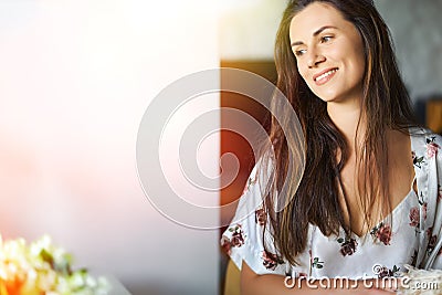 Woman in white pajamas sitting at a desk in the sunshine Stock Photo
