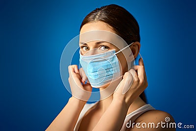 Woman in white shirt shows how to wear a mask during a pandemic Stock Photo