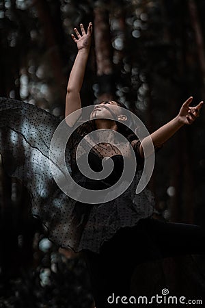 Beautiful women with black ballet costumes flying in the air like reaching something in the sky Stock Photo