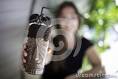 Beautiful women blurred holding a chocolate shake and cookies on a transparent glass with aboriginal design Stock Photo