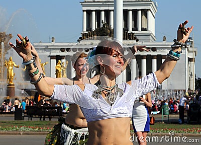 Beautiful women dansing at Cosplay festival on a background of the fountain Friendship of Nations Editorial Stock Photo