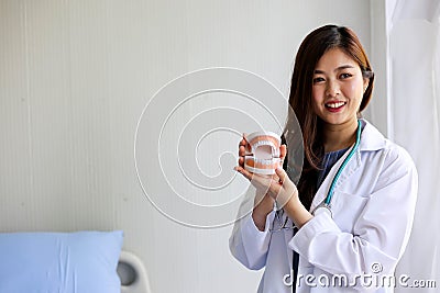 Beautiful woman dentist doctor pointing teeth model,dental checking concept Stock Photo