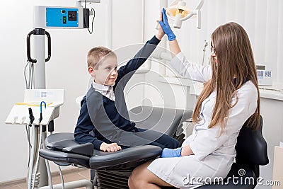 Beautiful woman dentist giving his little patient a high five Stock Photo