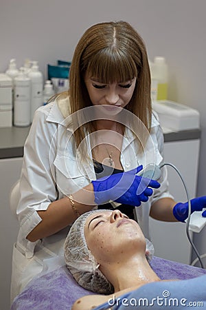 Beautician makes facial massage to a woman. Stock Photo