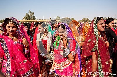 Beautiful women in red sari going through the crowd Editorial Stock Photo