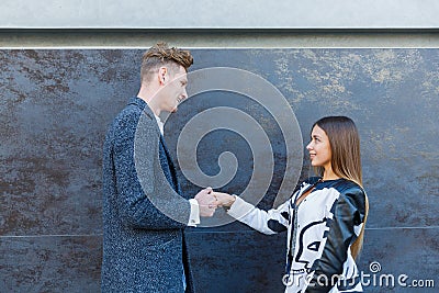 A beautiful woman smiles, shaking the man`s hand. Stock Photo