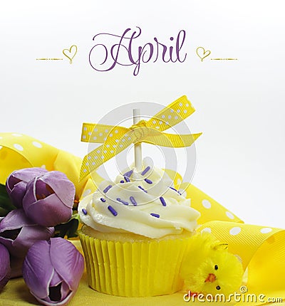 Beautiful yellow Spring or Easter theme cupcake with seasonal flowers tulips and decorations for the month of April Stock Photo