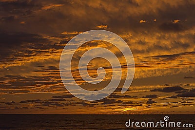 Beautiful yellow sundown over the sea with many clouds Stock Photo