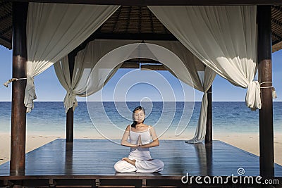 Beautiful yoga woman at luxury beach resort Stock Photo