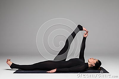 Beautiful yoga woman practice yoga poses on grey background. Stock Photo