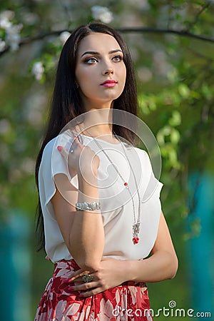 Beautiful yong model wearing luxury jewelry in blooming spring g Stock Photo