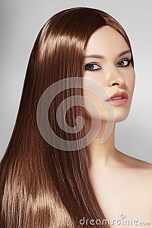 Beautiful yong Woman with Long Straight Brown Hair. Fashion Model with Smooth Gloss Hairstyle. Keratine Treatment Stock Photo