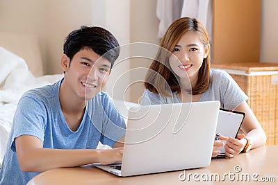 Beautiful young asian couple calculate expenses finance with laptop and planning together, woman writing notebook Stock Photo