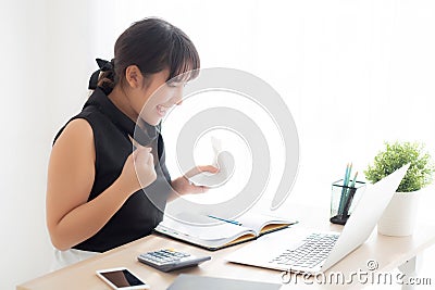 Beautiful young asian woman calculating finance household and writing notebook on desk Stock Photo