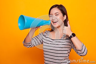 Beautiful young Asian woman show thumbs up announce with megapho Stock Photo