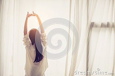 Beautiful young asian woman stretch and relax in bed after wake up morning at bedroom. Stock Photo