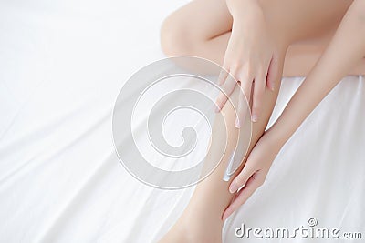 Beautiful young asian woman touch skin leg smooth with cream and lotion for hydration and smooth Stock Photo