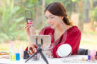 Beautiful young Asian woman making online product review at home Stock Photo