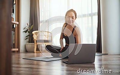 A beautiful young woman watching online workout tutorials on laptop at home Stock Photo