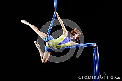 Beautiful young, athletic woman professional aerial circus artist with redhead in yellow costume posing diagonal in the air, Stock Photo