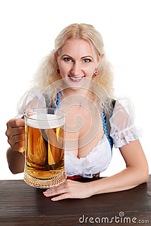 Beautiful young blond girl in traditional costume drinks out of oktoberfest beer stein. Stock Photo